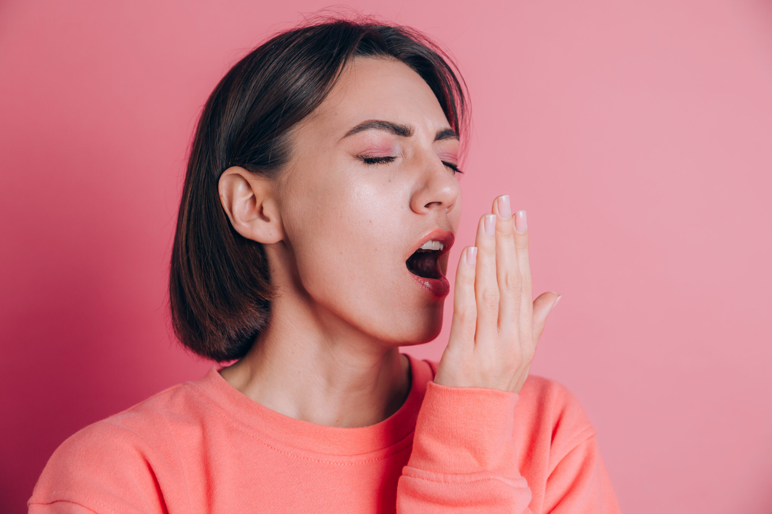 Woman cupping her hand in front of her open mouth to check for bad breath
